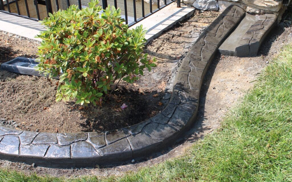 Stamped concrete landscape edging around a shrub bed in Bethesda, MD