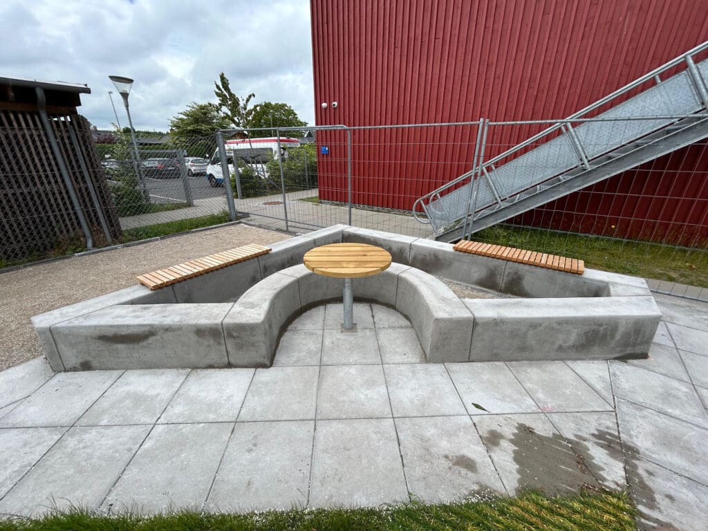 Commercial concrete curbing installation around outdoor seating area with steps and walkway